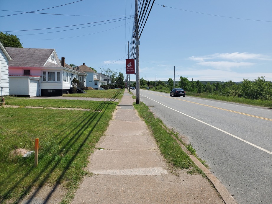 Picture of a sidewalk between homes and a road